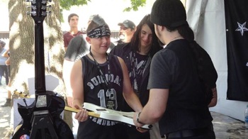 Fan having a guitar autographed at the Crazy Dave's Music Experience